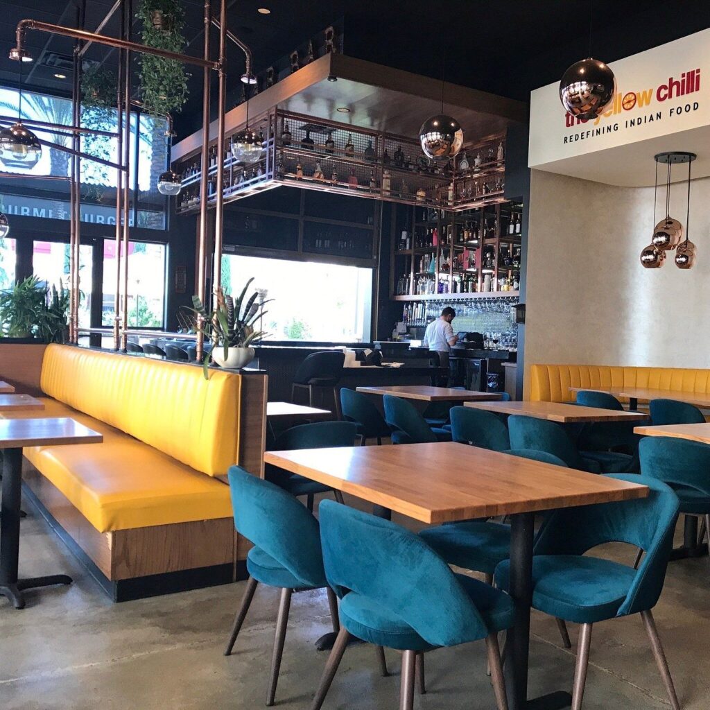 Central interior transition area between dining room and bar counter at The Yellow Chilli USA by Urban Box Studio
