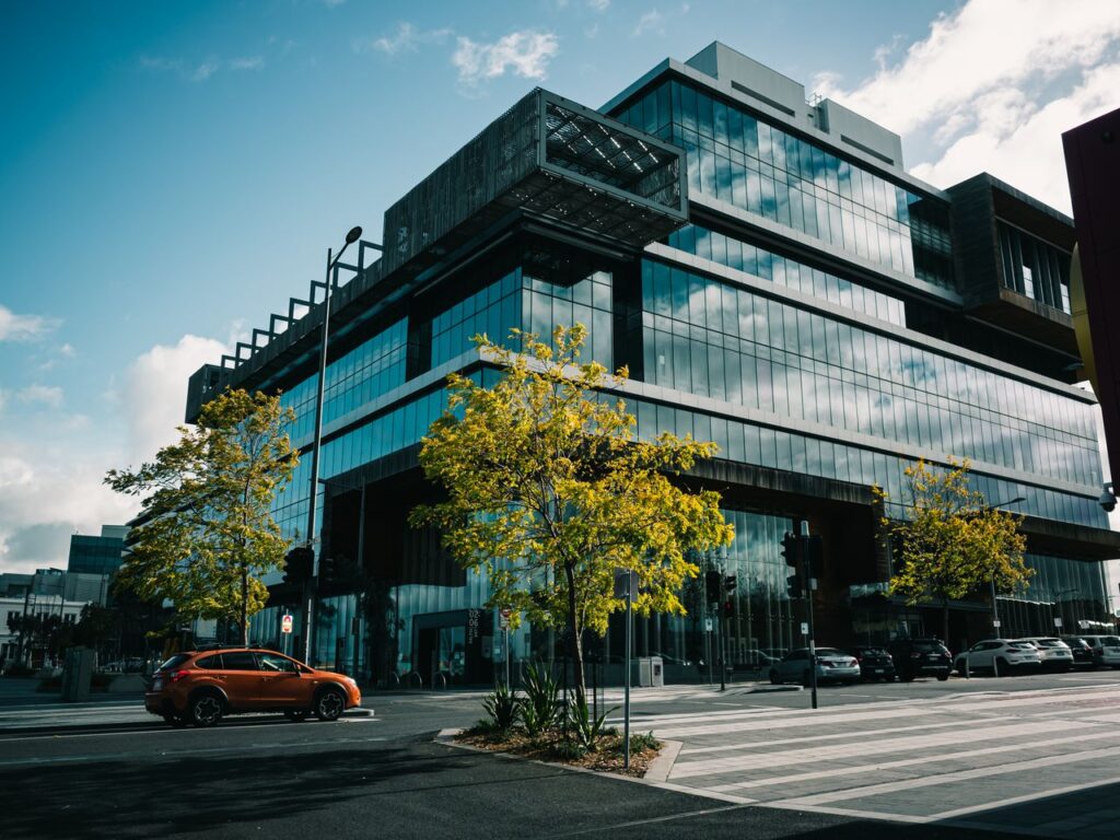 Exterior of a modern office building with glass facade and urban streetscape.