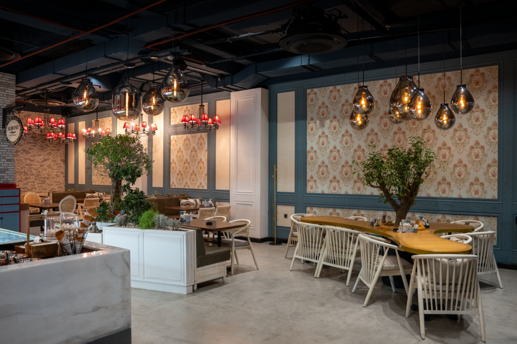 Stylish cafe interior in Erbil with modern chandeliers and elegant seating arrangement.