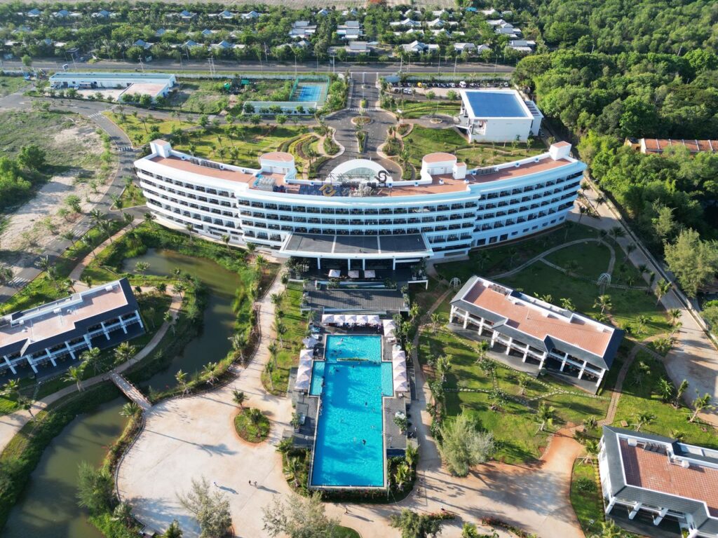 Stunning aerial view of a modern resort with a huge pool in Hồ Tràm, Vietnam.