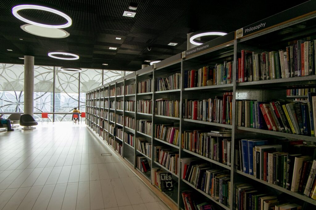A quiet modern library interior with bookshelves and bright circular lights.