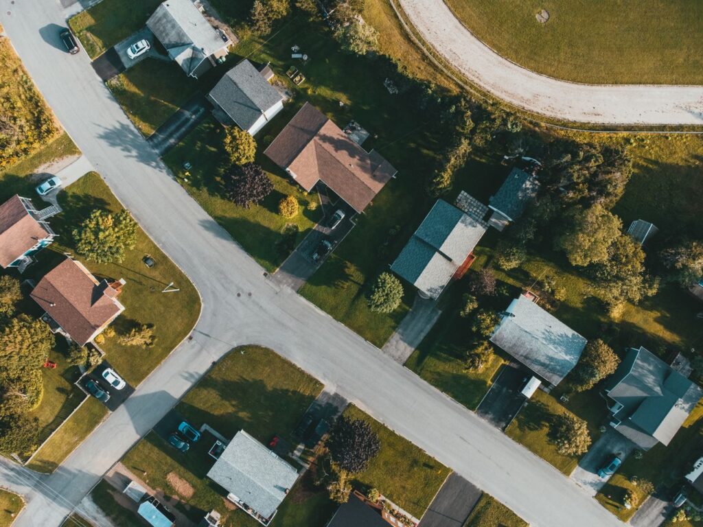 Bird's eye view of a suburban neighborhood with tree-lined streets and houses.